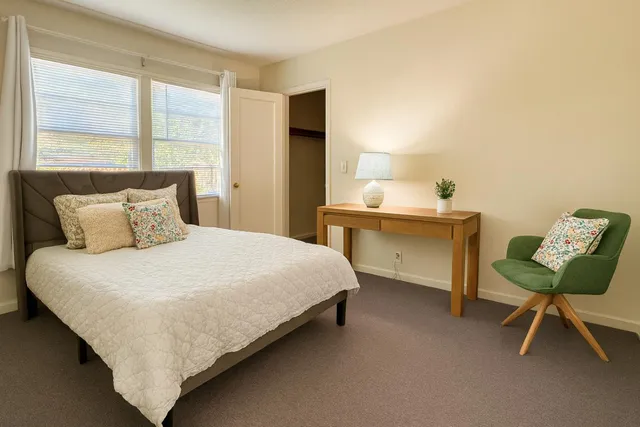 a bedroom with a bed chair and a window