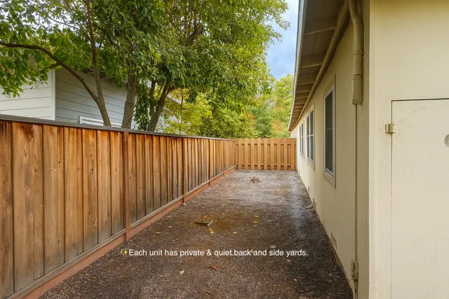 a view of a pathway of a building with wooden fence