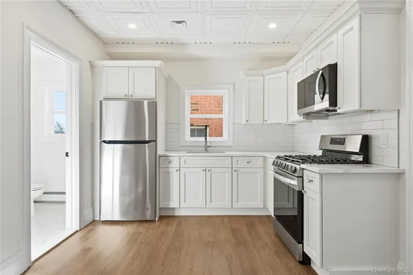 a kitchen with stainless steel appliances a refrigerator stove and microwave