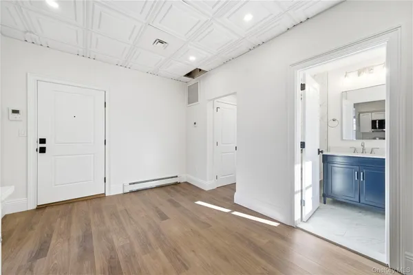 a view of an empty room with closet and wooden floor
