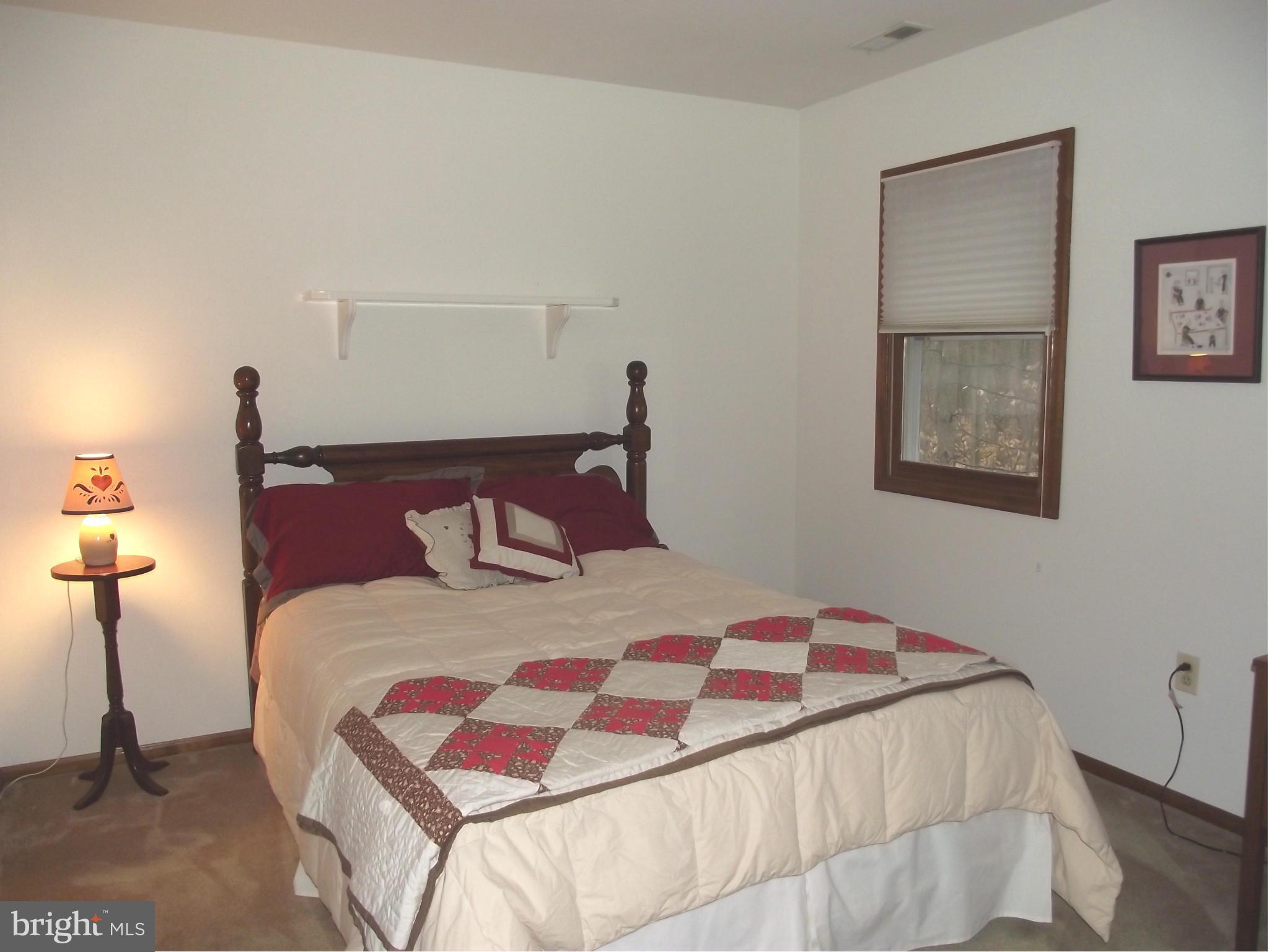 135 Thomas Gantt Road Huntingtown, MD 20639 - Photo 22 of 26 a bedroom with a bed and a night stand