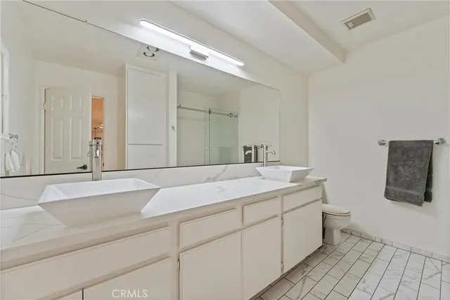 a bathroom with a sink and mirror with toilet