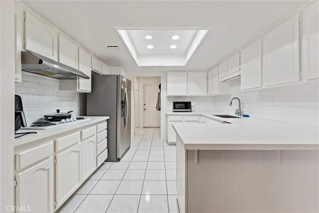 a kitchen with a sink a refrigerator and cabinets