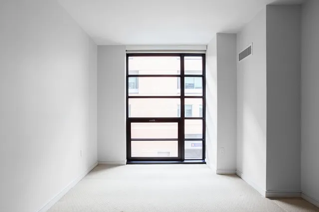 an empty room with windows and closet