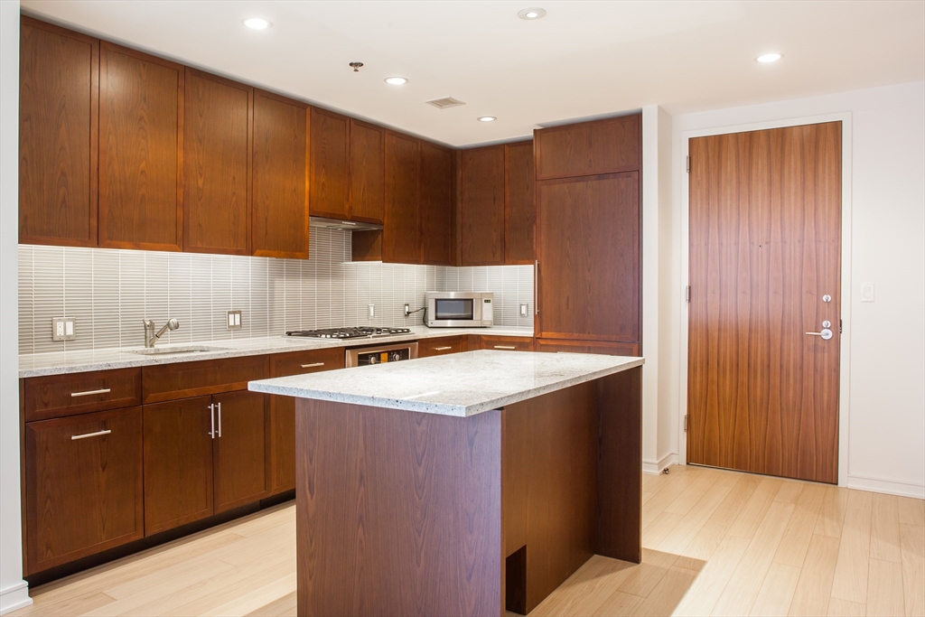 580 Washington Street, Unit 304 Boston, MA 02111 - Photo 8 of 18 a kitchen with a sink and cabinets