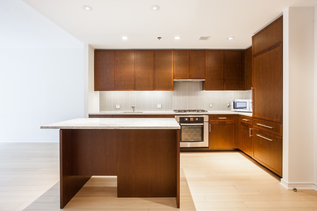 580 Washington Street, Unit 304 Boston, MA 02111 - Photo 9 of 18 a kitchen with a stove and a microwave