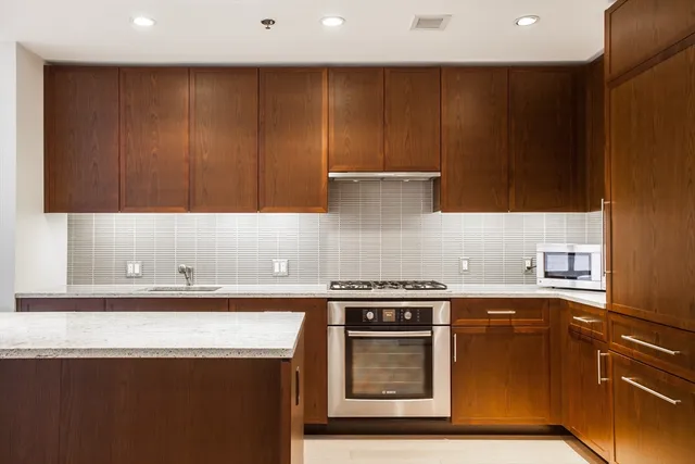 a kitchen with stainless steel appliances wooden cabinets and a stove top oven