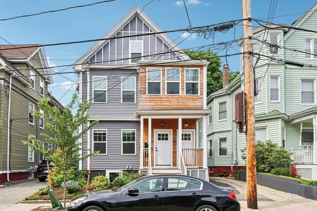 26 Robinson Street, Unit 26 Somerville, MA 02145 - Photo 23 of 29 a front view of a residential apartment building with a yard