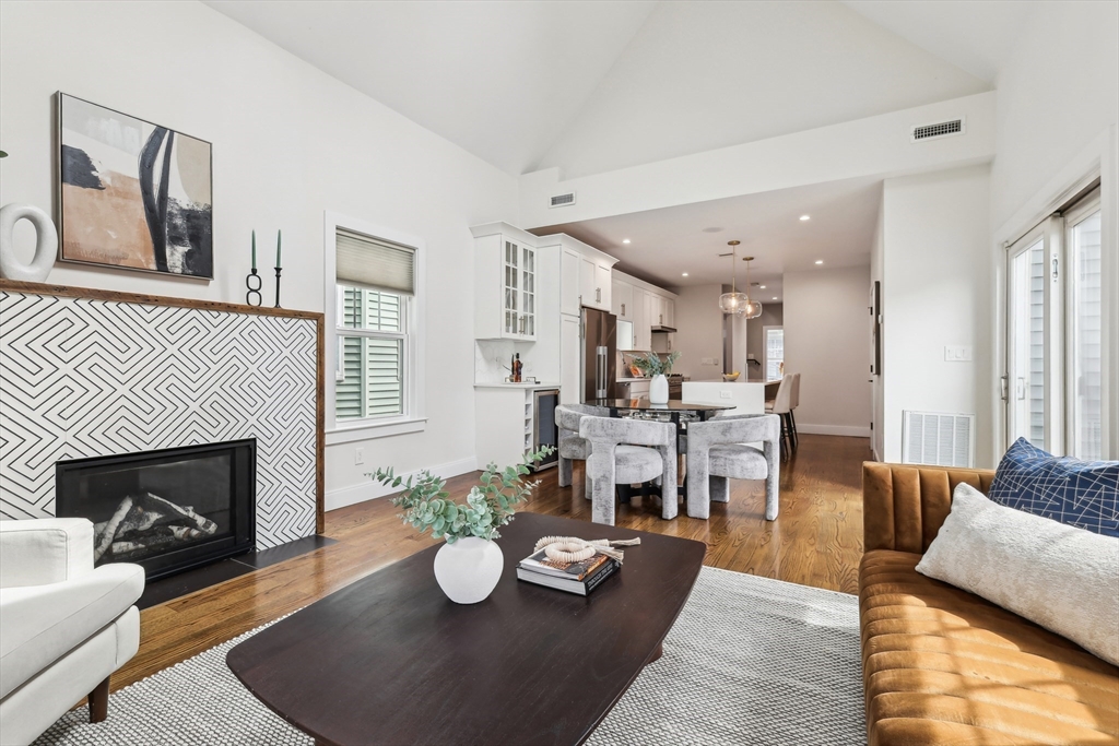 26 Robinson Street, Unit 26 Somerville, MA 02145 - Photo 3 of 29 a living room with furniture kitchen view and a fireplace