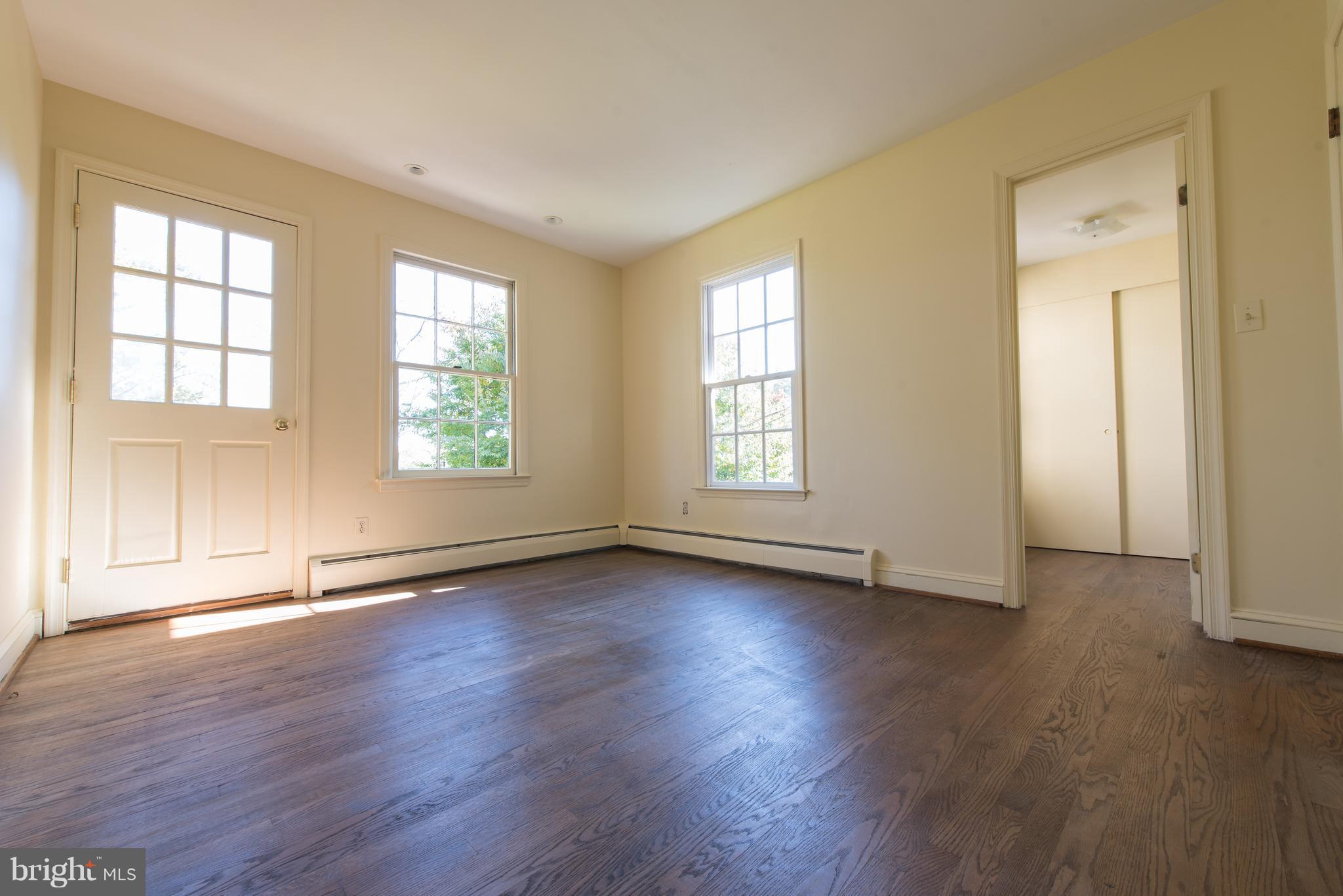 3645 Macalpine Road Ellicott City, MD 21042 - Photo 26 of 30 an empty room with wooden floor and windows with curtains view