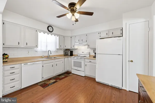 a kitchen with white cabinets and white appliances