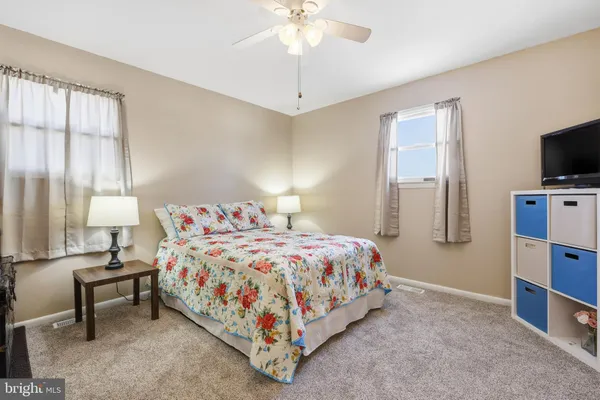 a bedroom with a bed and a flat tv screen on dresser