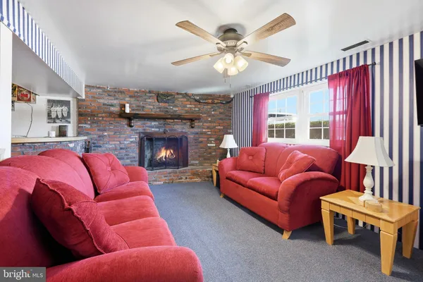 a living room with furniture a fireplace and a large window