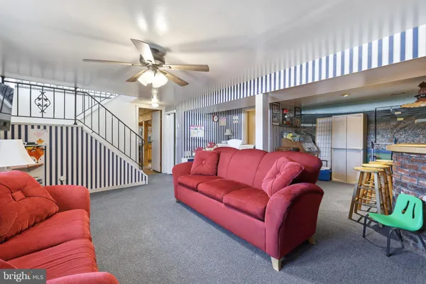 a living room with furniture ceiling fan and a rug