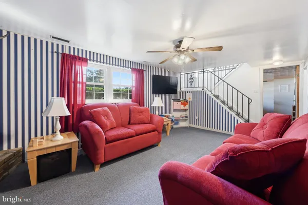 a living room with furniture ceiling fan and a rug