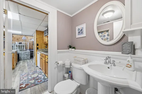 a spacious bathroom with a toilet a sink and a mirror