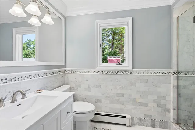 a bathroom with a sink a toilet and a mirror