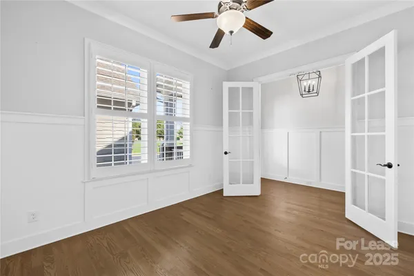 a view of a hallway with wooden floor and windows