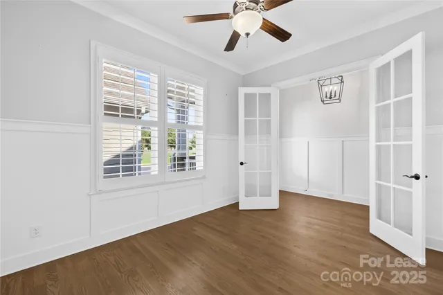 a view of a hallway with wooden floor and windows