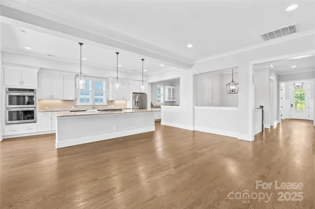 a kitchen with stainless steel appliances granite countertop a sink a refrigerator and a stove