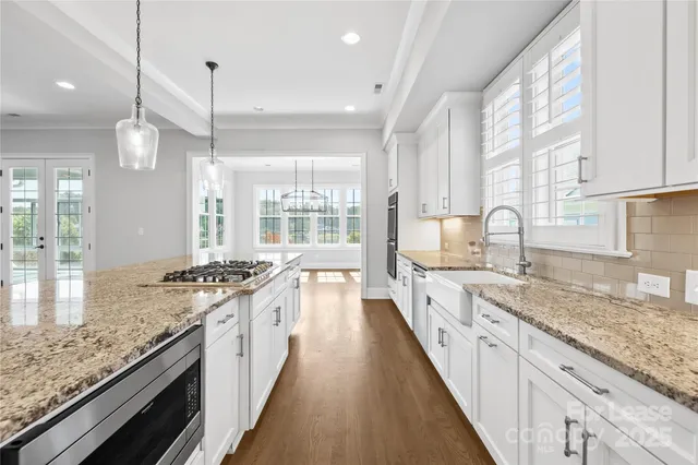 a kitchen with stainless steel appliances granite countertop a stove and a wooden floors
