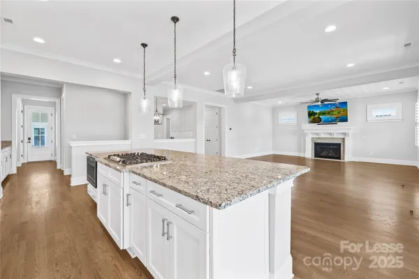 a large kitchen with kitchen island granite countertop a large counter top a sink stainless steel appliances and windows