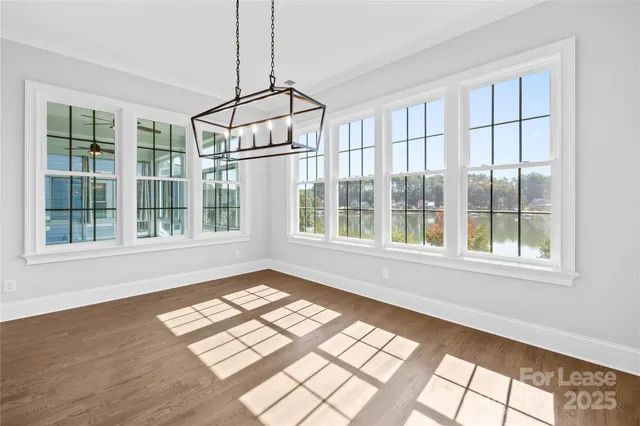 a large kitchen with stainless steel appliances granite countertop a stove a sink a center island and a wooden floor