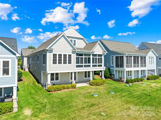 a view of a house with a big yard potted plants and large tree