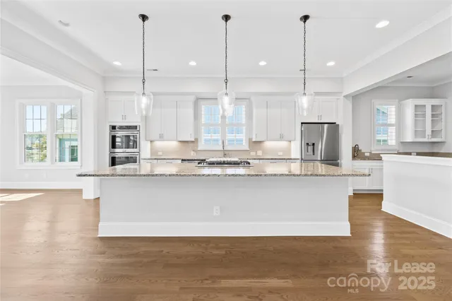 a kitchen with granite countertop white cabinets and a sink
