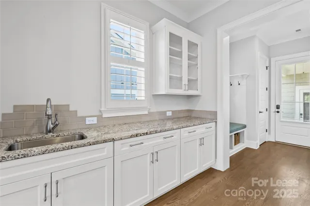 a living room with a large window and a chandelier