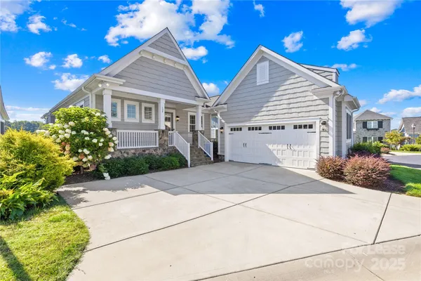 a front view of a house with a yard and potted plants