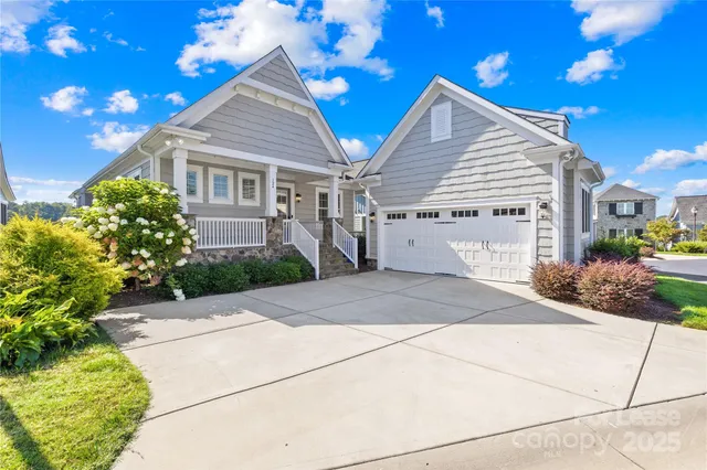 a front view of a house with a yard and potted plants