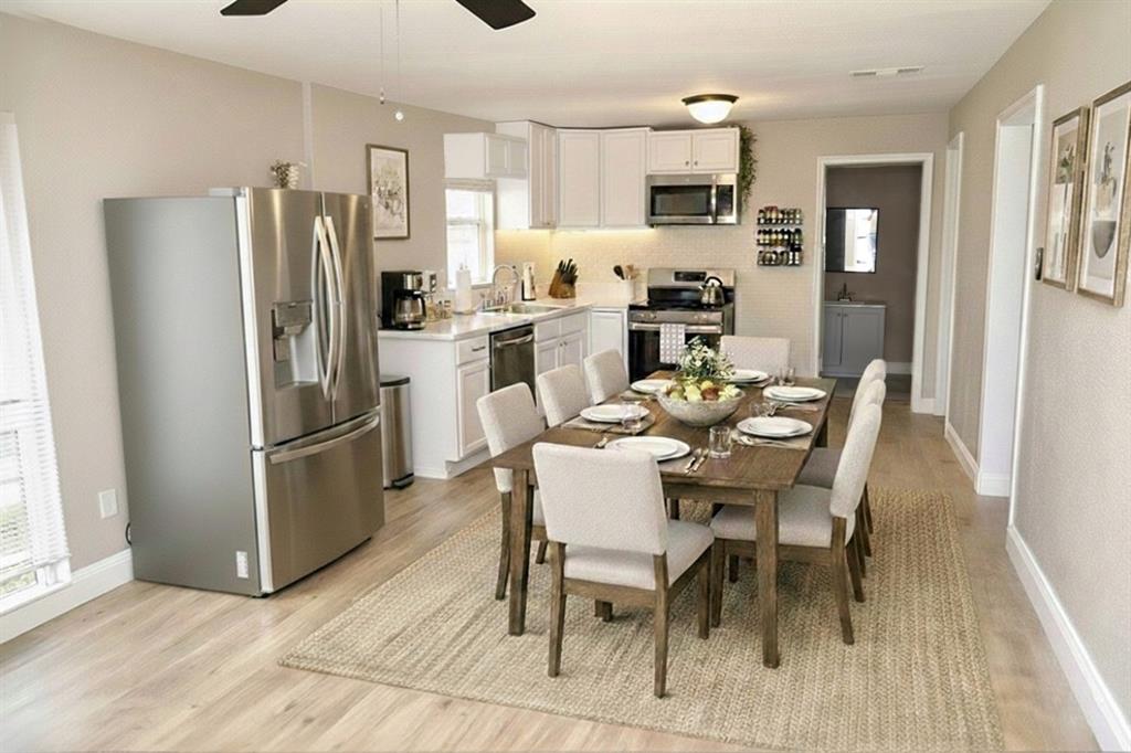 515 Taylor Street Arlington, TX 76011 - Photo 5 of 18 a kitchen with a refrigerator a dining table and chairs