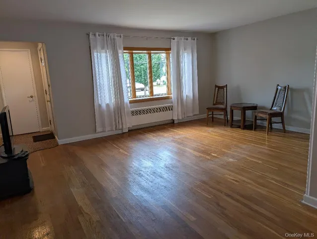 a view of a room with wooden floor and a window