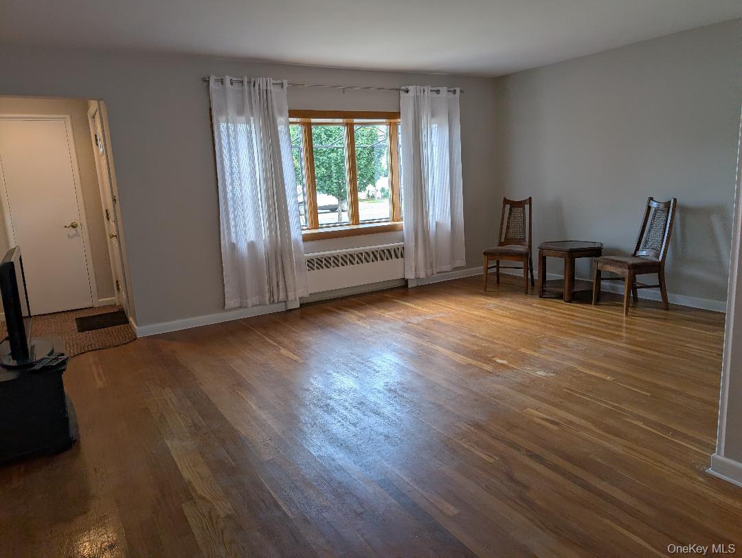 483 South Oyster Bay Road Plainview, NY 11803 - Photo 2 of 9 a view of a room with wooden floor and a window
