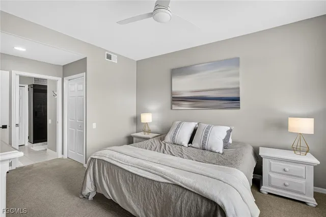 a bedroom with a bed and a lamp on dresser