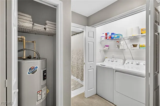a utility room with fridge dryer and washer