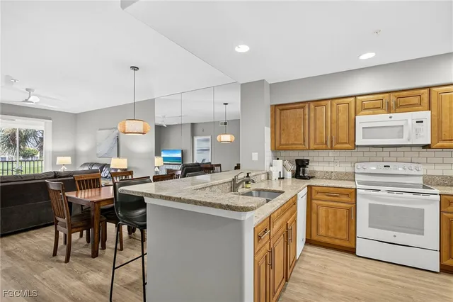a kitchen with a stove a sink a dining table and chairs