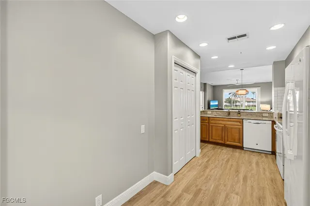 a kitchen with a refrigerator and white cabinets