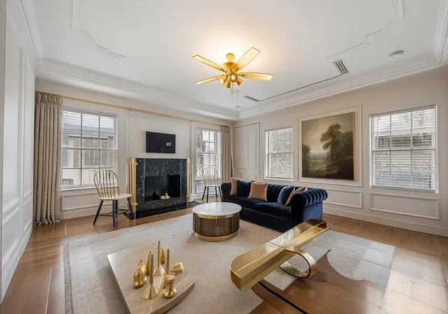 a living room with furniture large window and fireplace