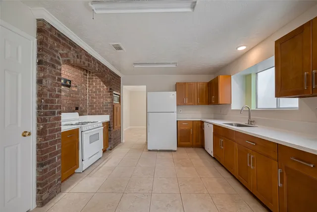 a large kitchen with a stove and a refrigerator
