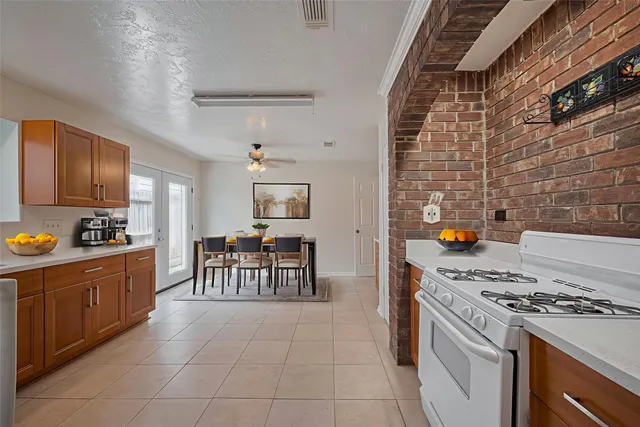 a kitchen with granite countertop a stove top oven a sink a dining table and chairs