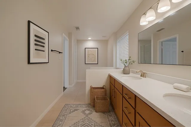 a spacious bathroom with a double vanity sink and a mirror