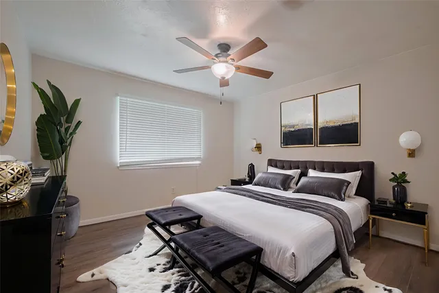 a bedroom with a bed and a potted plant on the dresser