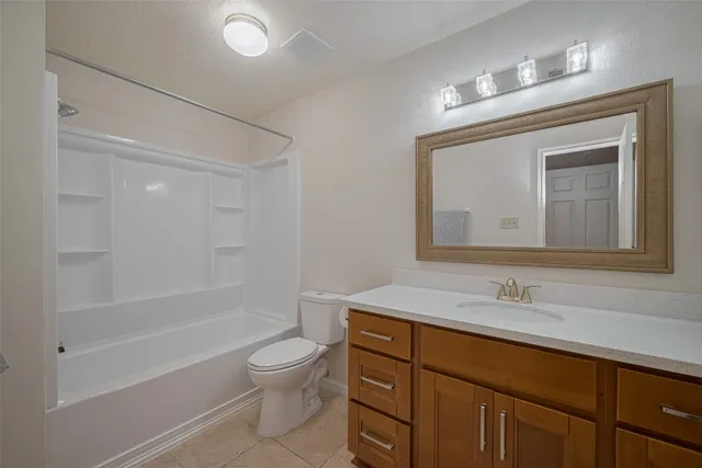 a bathroom with a toilet a sink a mirror a bathtub and vanity