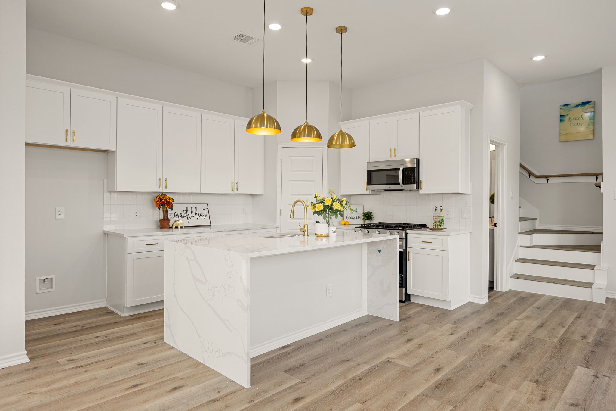 2720 Spence Street Houston, TX 77093 - Photo 14 of 50 a kitchen with kitchen island white cabinets stainless steel appliances and wooden floor