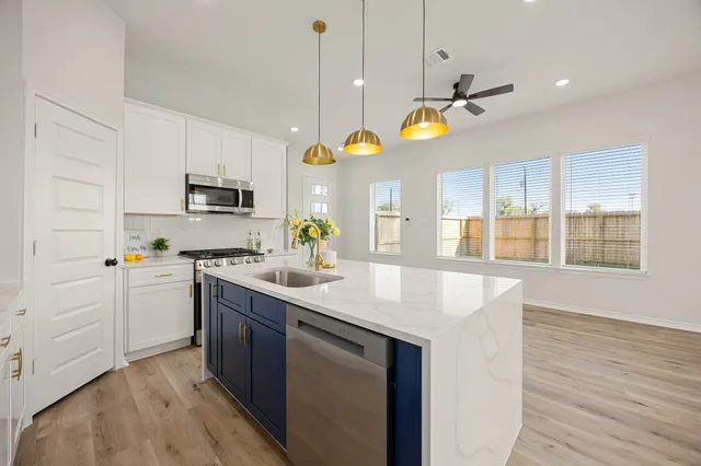 a kitchen with cabinets and wooden floor