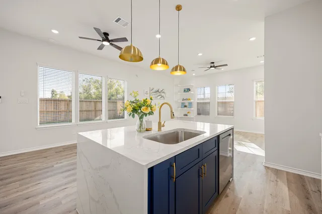 a kitchen with a sink a counter space and a wooden floor