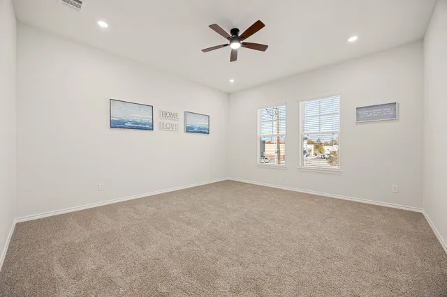 an empty room with a window and a ceiling fan