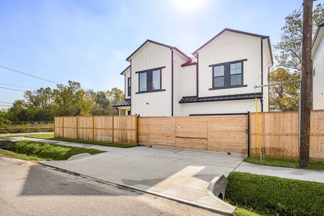 a view of a white house with a small yard and large window
